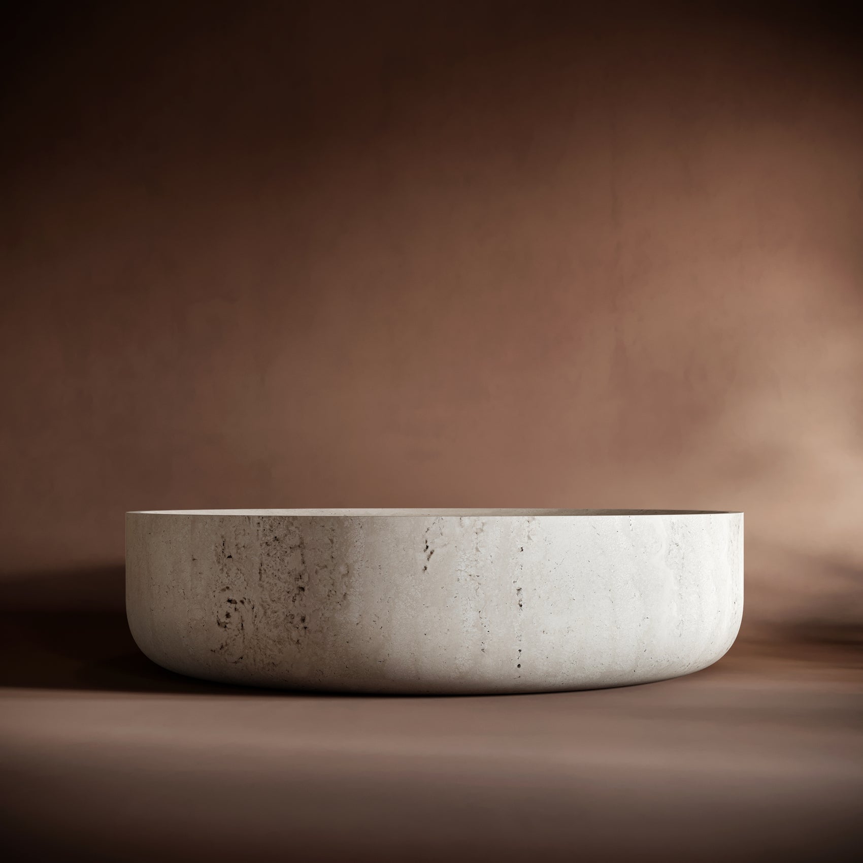Elegant CARLO travertine coffee table set against a warm brown background, emphasizing its monolithic design.