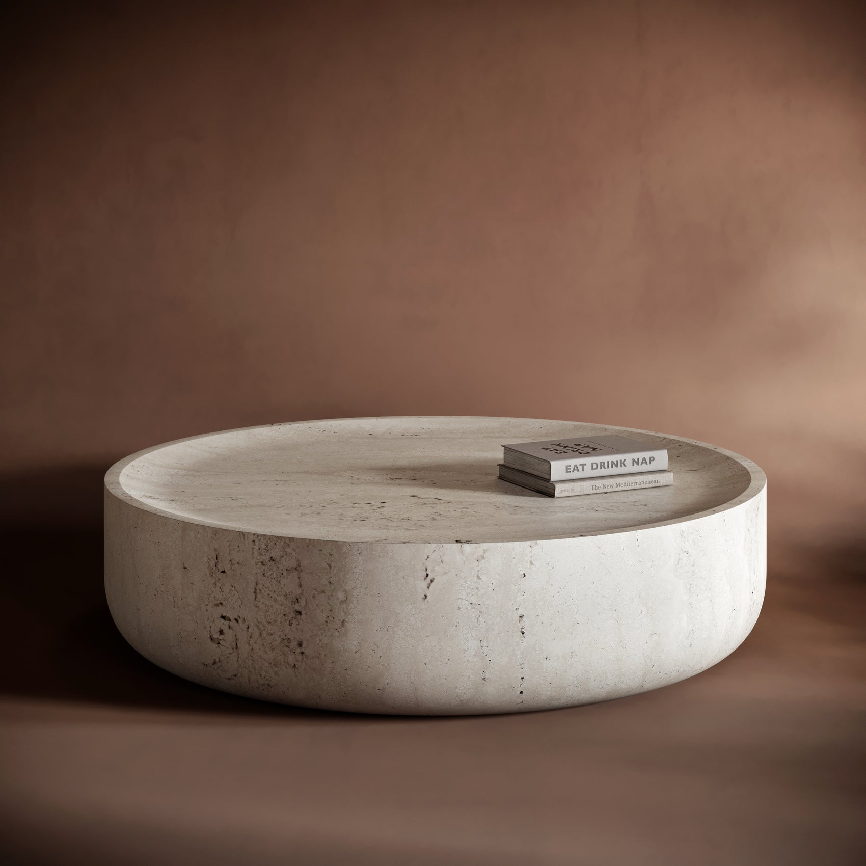 CARLO monolithic travertine coffee table with a round, seamless design and natural stone textures.