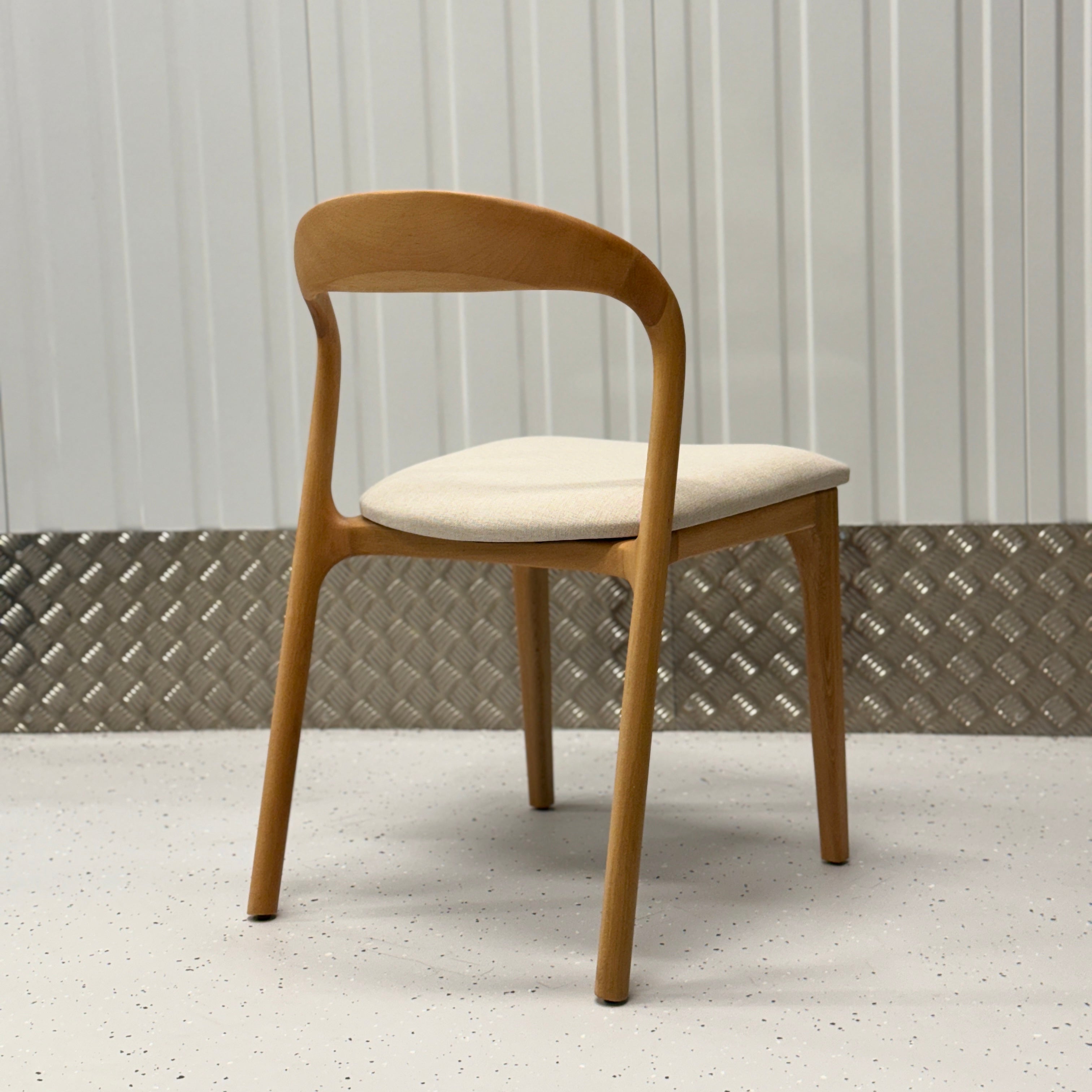 Handcrafted wooden dining chair featuring a minimalist profile and durable construction, perfect for versatile home decor
