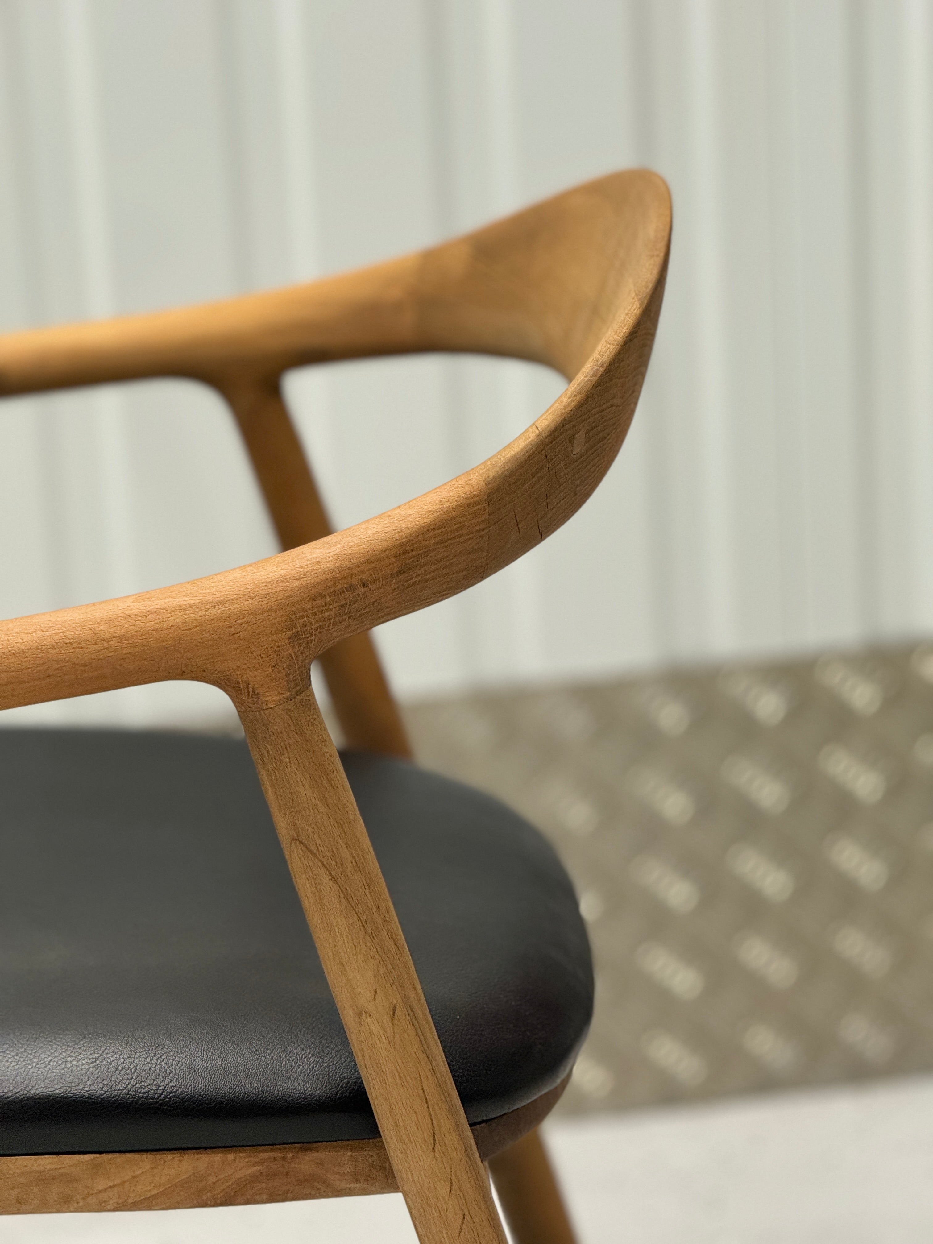 Elegant wooden chair with a curved oak backrest and sturdy frame, designed for long-lasting use and timeless appeal.