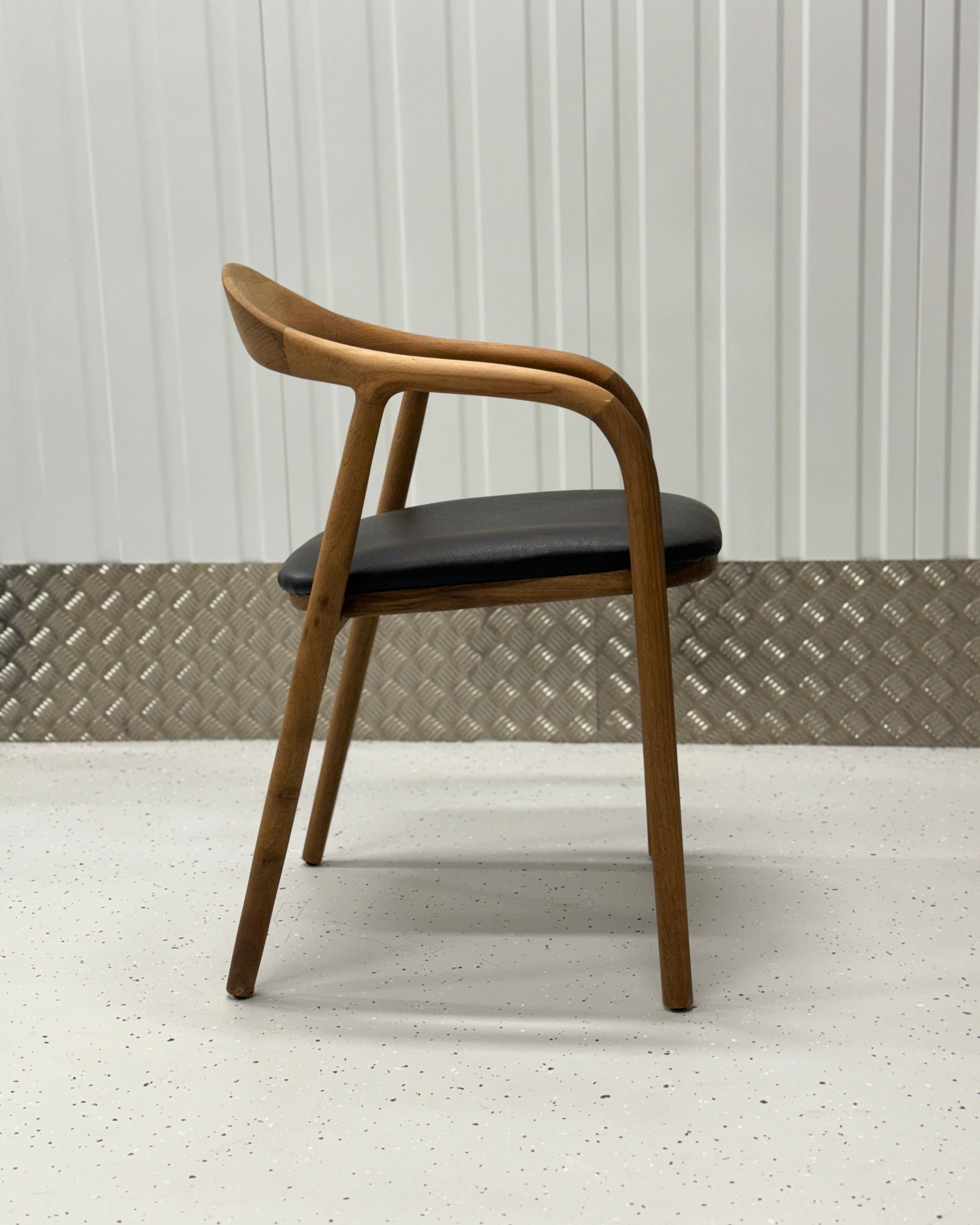 Iconic N-Chair with a gracefully curved oak backrest and timeless design, ideal for modern dining furniture setups.