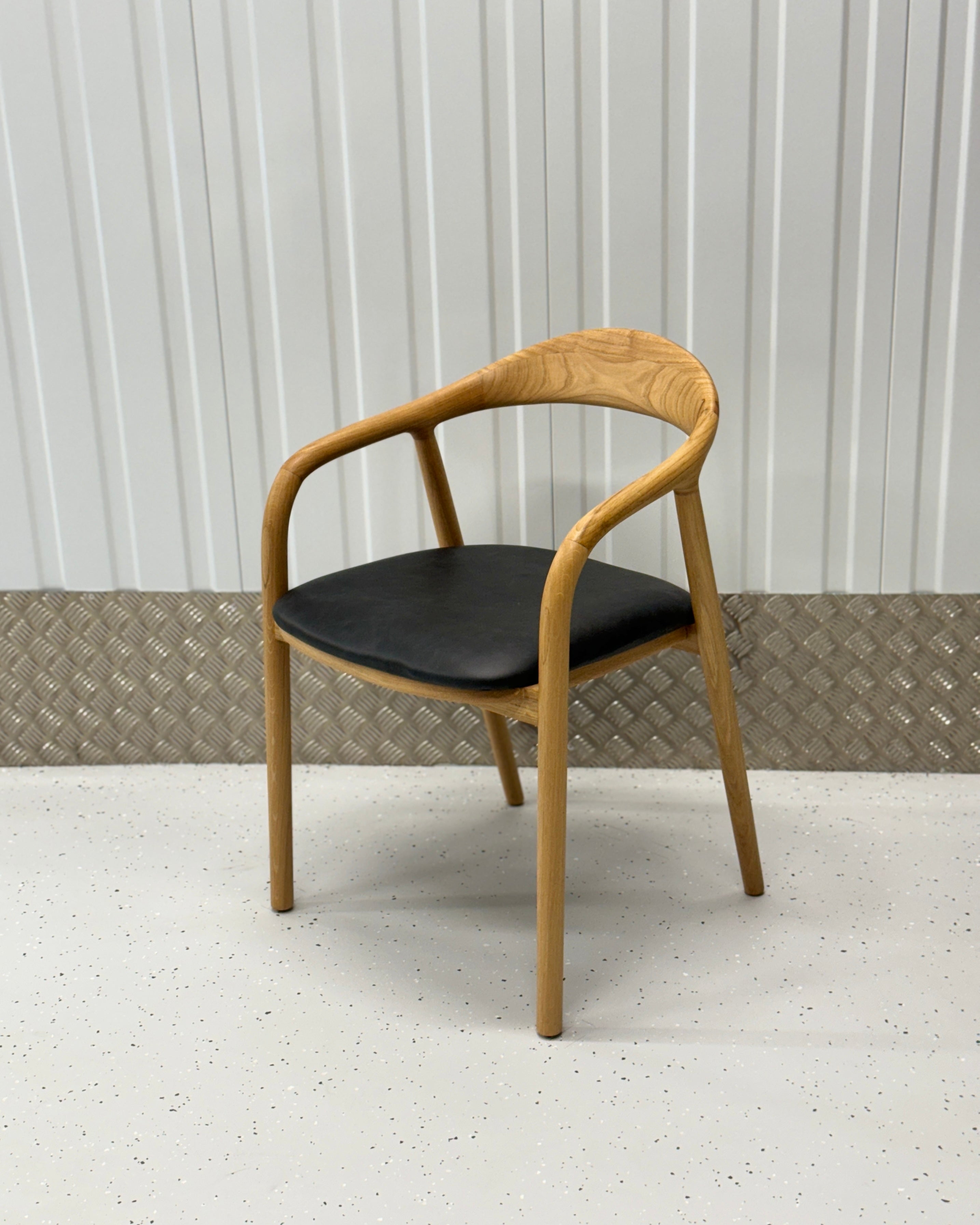 N-Chair with a solid oak frame and curved backrest, designed to complement modern and classic home decor styles.
