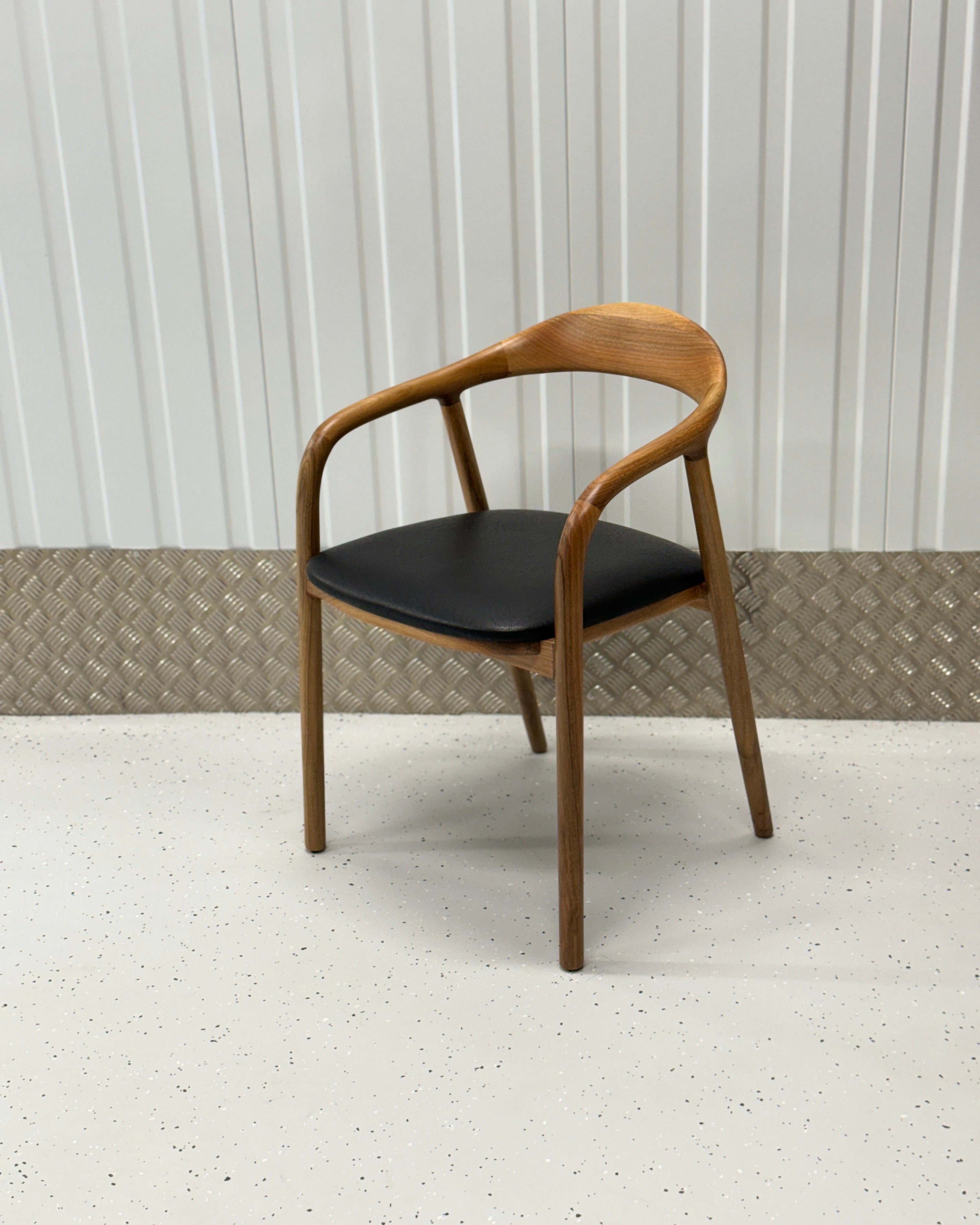 N-Chair in a rich walnut finish, featuring a curved backrest and solid wood frame, perfect for modern and classic interiors.
