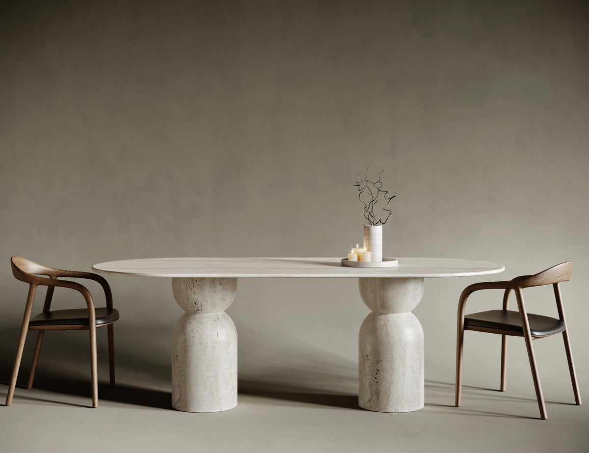 Elegant dining room featuring an oval travertine dining table with sculptural hourglass legs. The natural stone surface showcases unique textures and organic patterns, creating a harmonious blend of modern design and timeless craftsmanship.