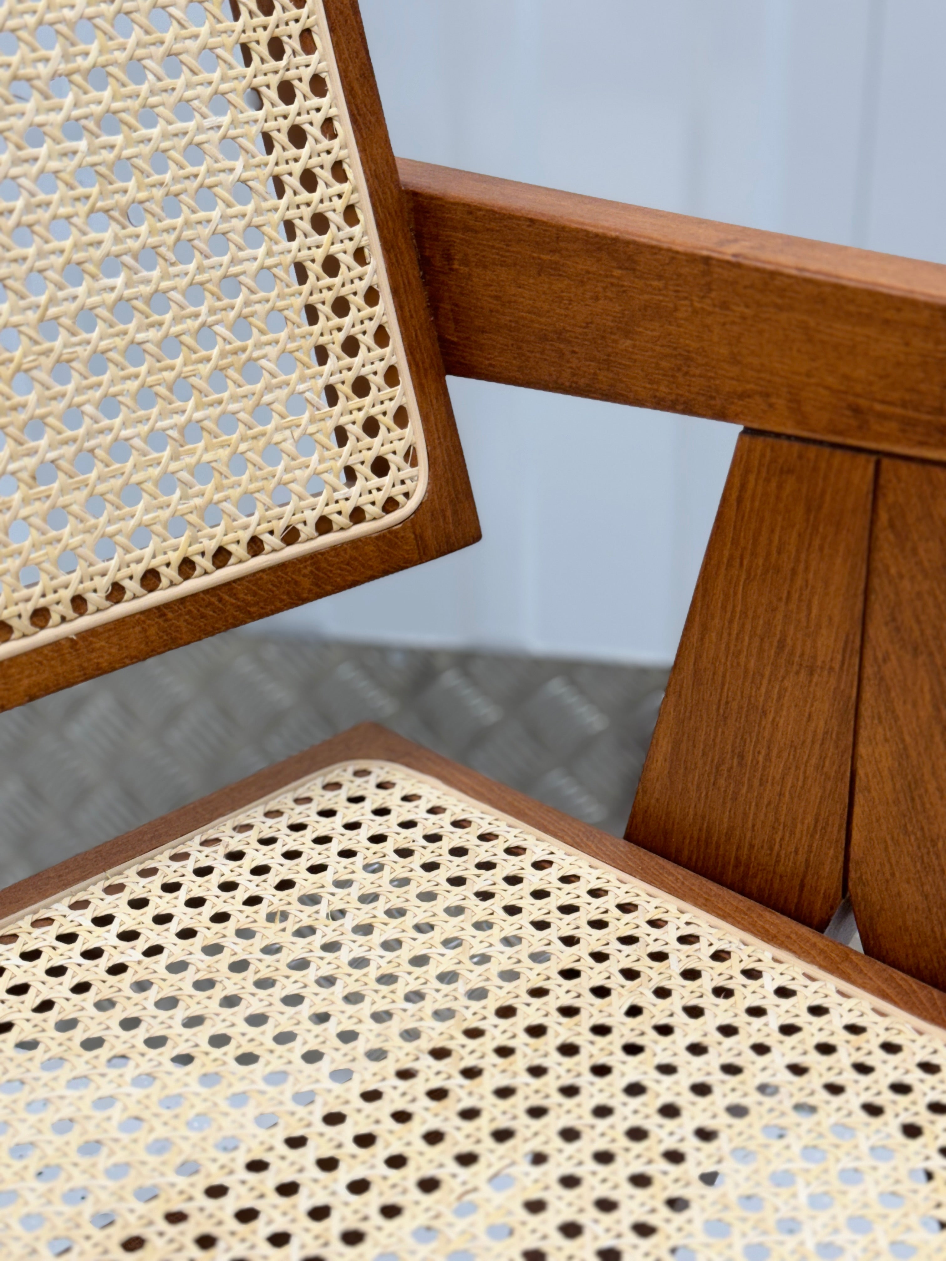Rattan dining chair with a minimalist solid wood structure, designed for comfort and style in modern interiors.