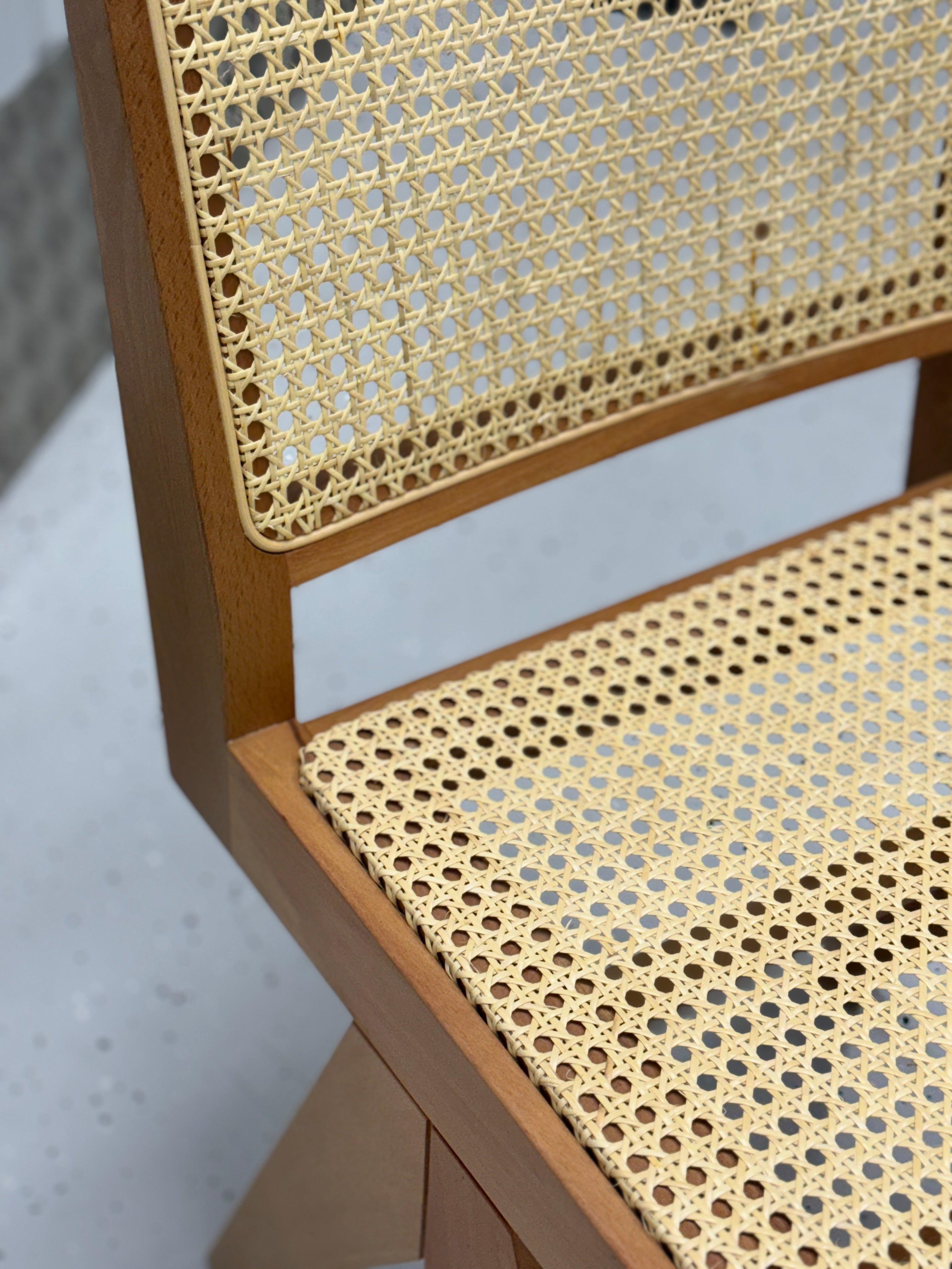 Lightweight rattan dining chair combining a sleek wooden frame and organic materials, designed for versatile home decor and lasting durability.