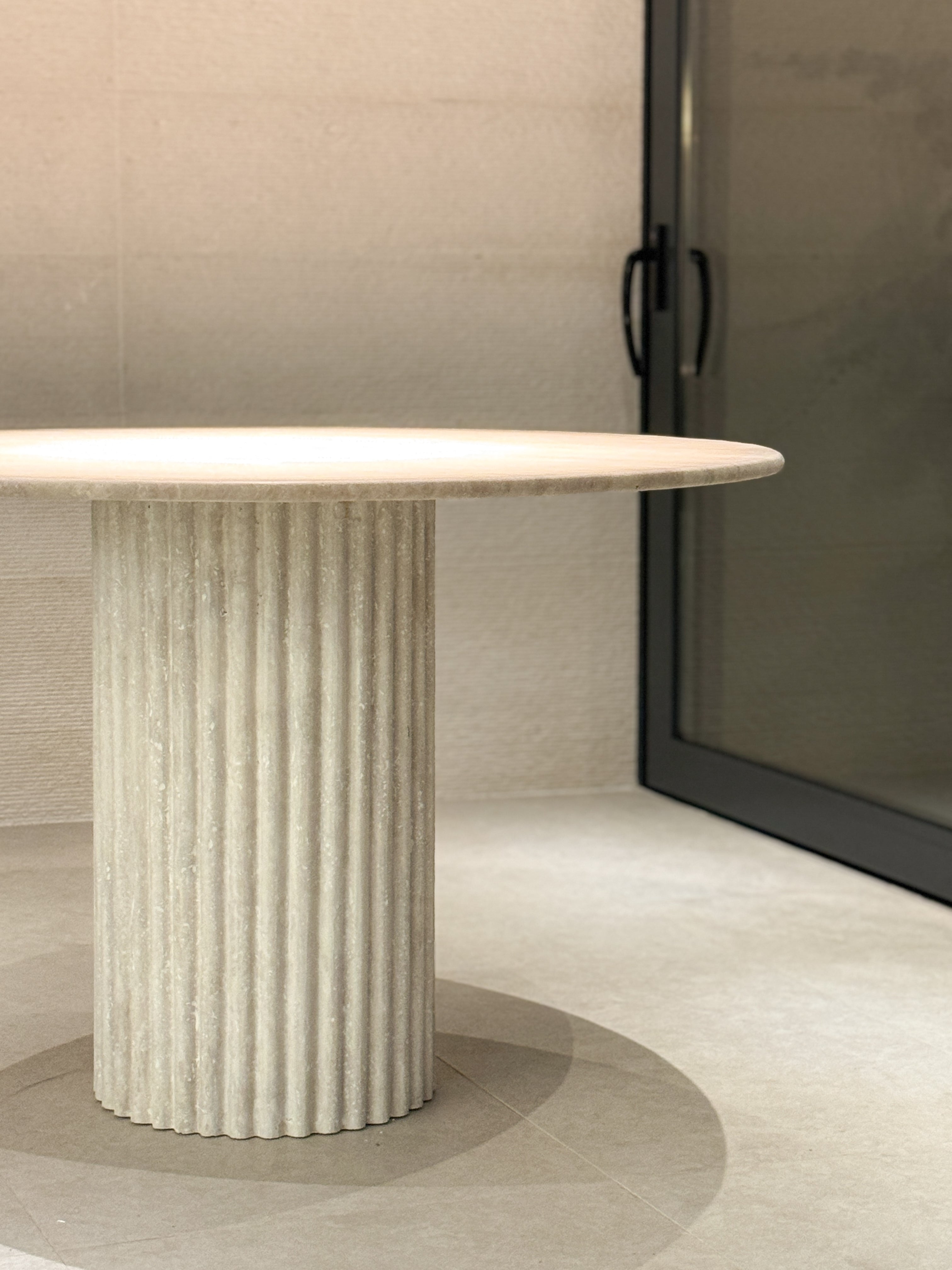 BEDÚ Atelier's vintage travertin tafel with its unique fluted leg, creating a sophisticated centerpiece in a neutral room.