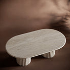 Handcrafted travertine coffee table with fluted bases and a smooth, elegant tabletop.
