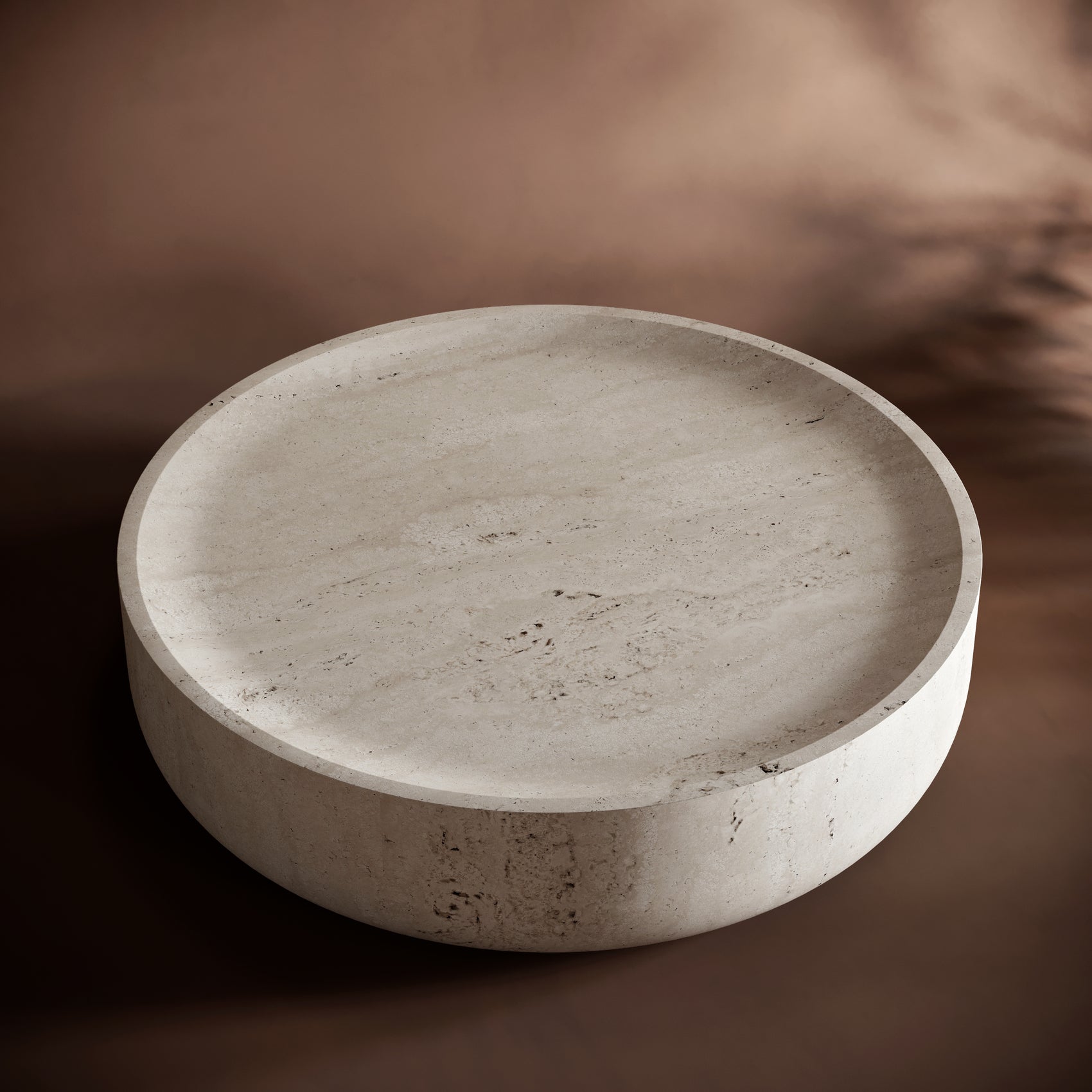 Lightweight travertine coffee table with a hollow underside, showcasing its sculptural form.
