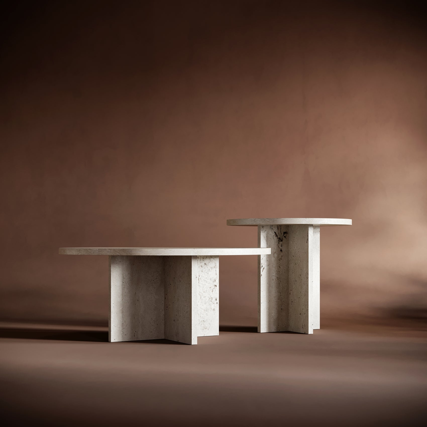 A dynamic arrangement of the ELENA travertine tables, showcasing their contrasting heights and sculptural elegance.
