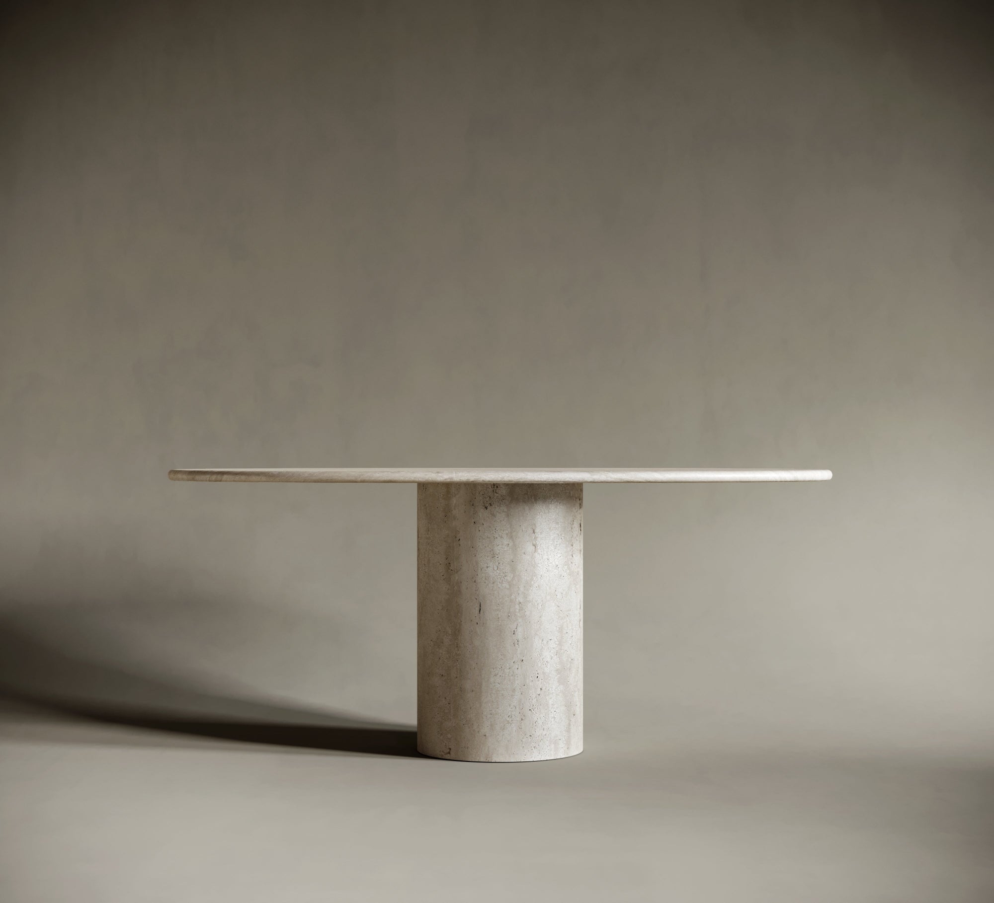 Side profile of natural travertin ellipse table with strong cylindrical base and honed texture.

