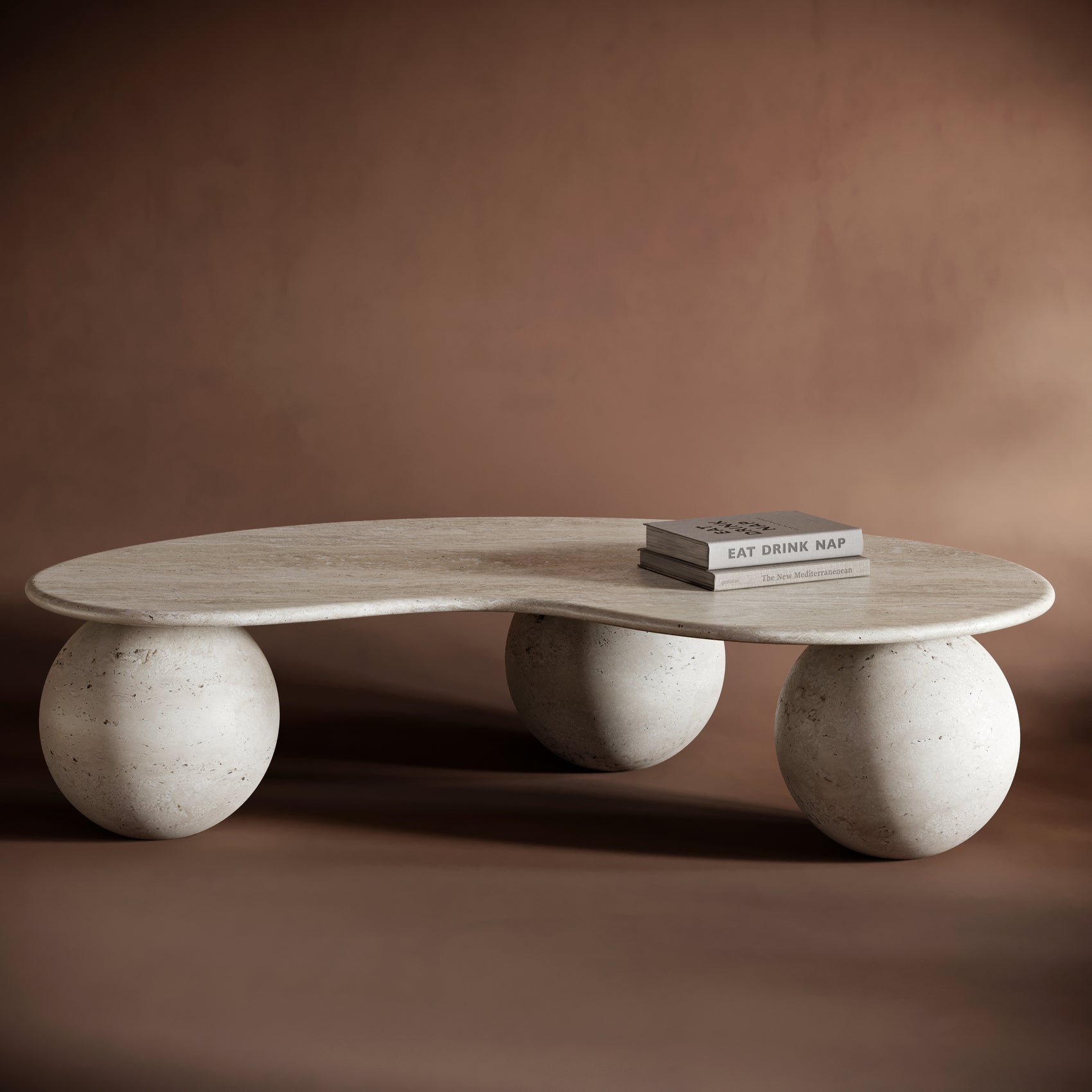 FABIO travertine coffee table with a free-form, flowing top and sculptural spherical bases, showcasing natural stone textures.
