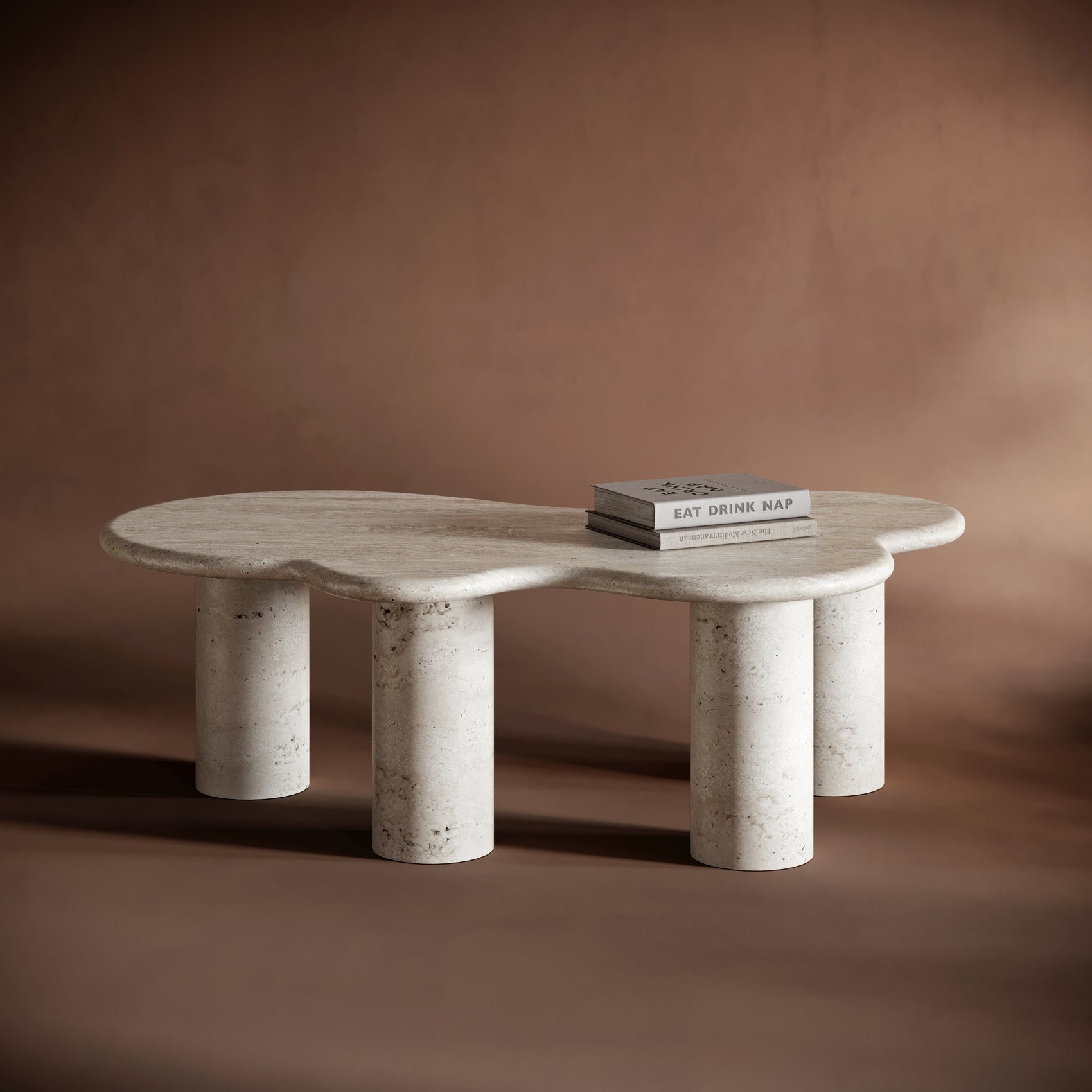 ISABELLA modern  organic travertine coffee table with a kidney-shaped top and cylindrical legs, showcasing natural stone textures.

