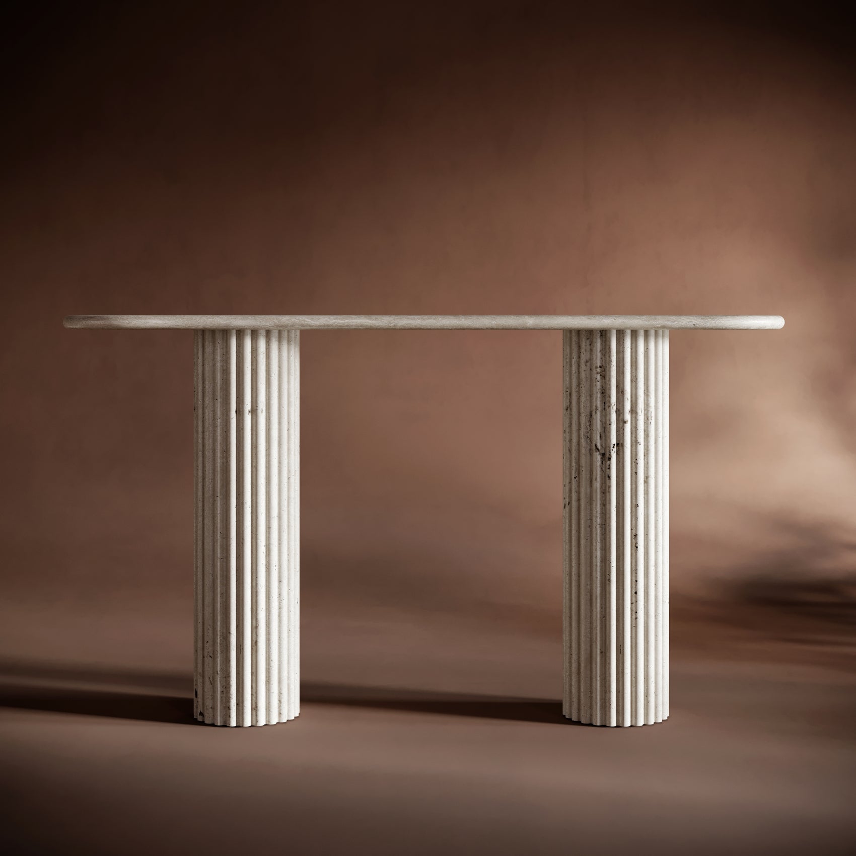Elegant travertine console table set against a warm brown background, emphasizing its timeless and sculptural design.
