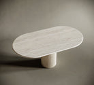 Modern oval travertine table with fluted base on a neutral background