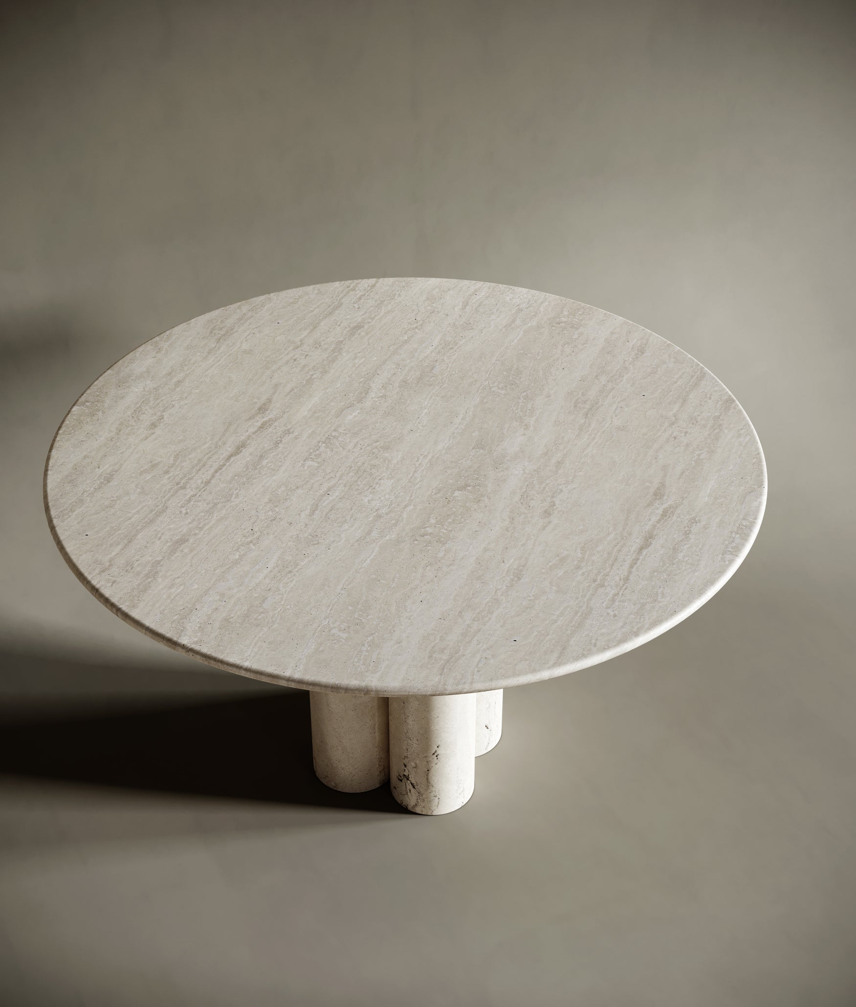 Close-up of a round travertine tabletop, highlighting its smooth, honed finish and natural stone texture. The light beige surface exudes organic beauty, making it a centerpiece for sophisticated interiors