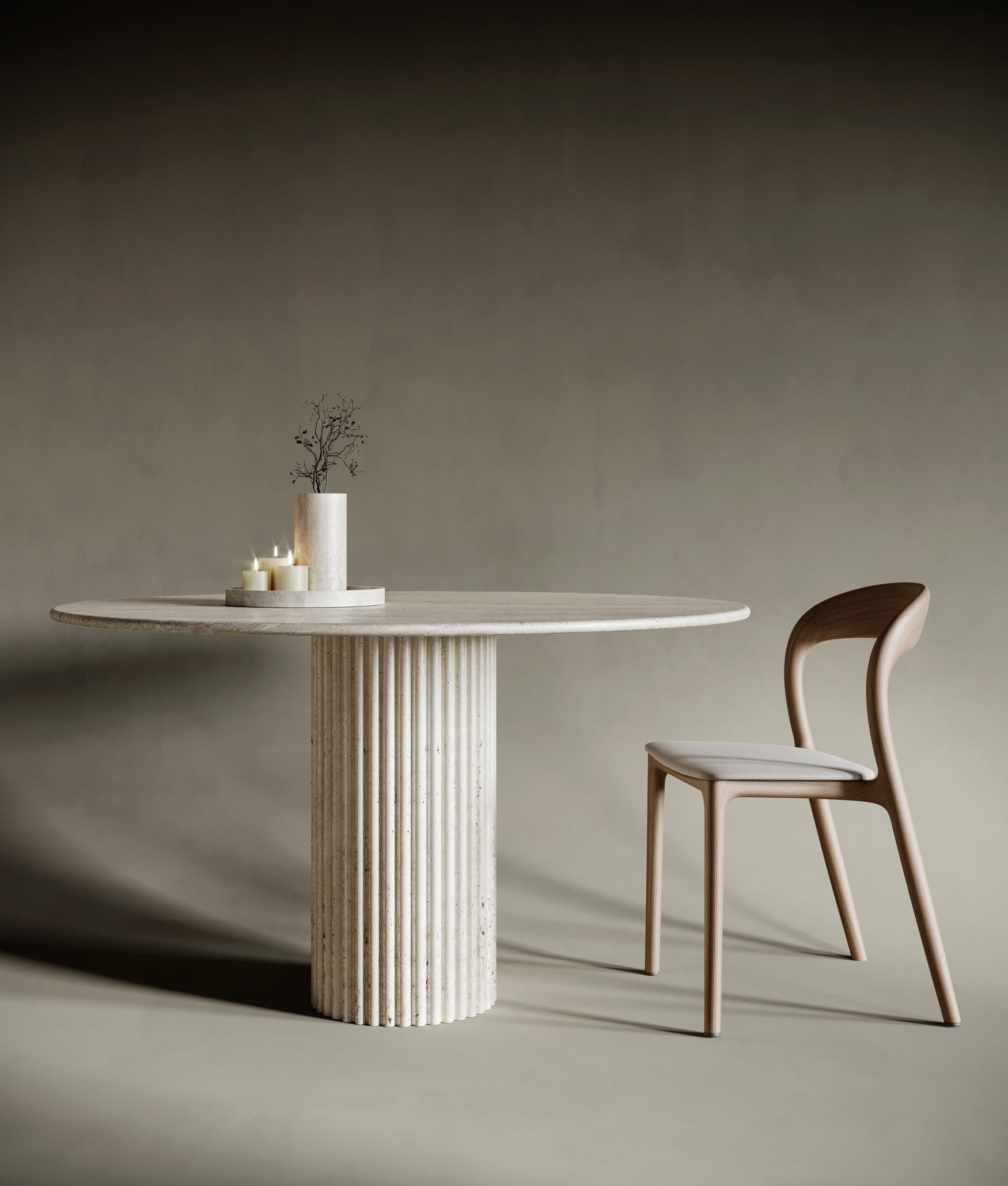 A minimalist round travertine dining table with a distinctive fluted column leg, set for a stylish dining experience.