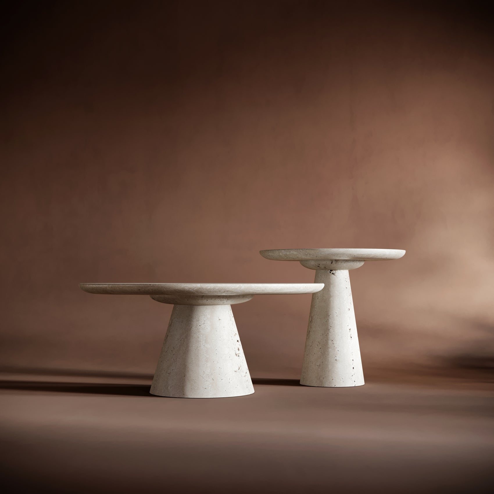 SOFIA travertine coffee table set arranged dynamically against a warm brown background, emphasizing its timeless design.
